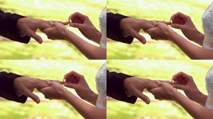 在慢镜头中，女子将戒指戴在新郎的手指上