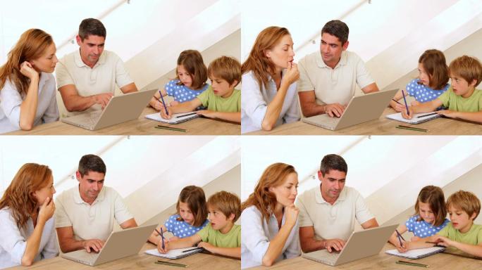 父母使用笔记本电脑，孩子在家里客厅的桌子上上色