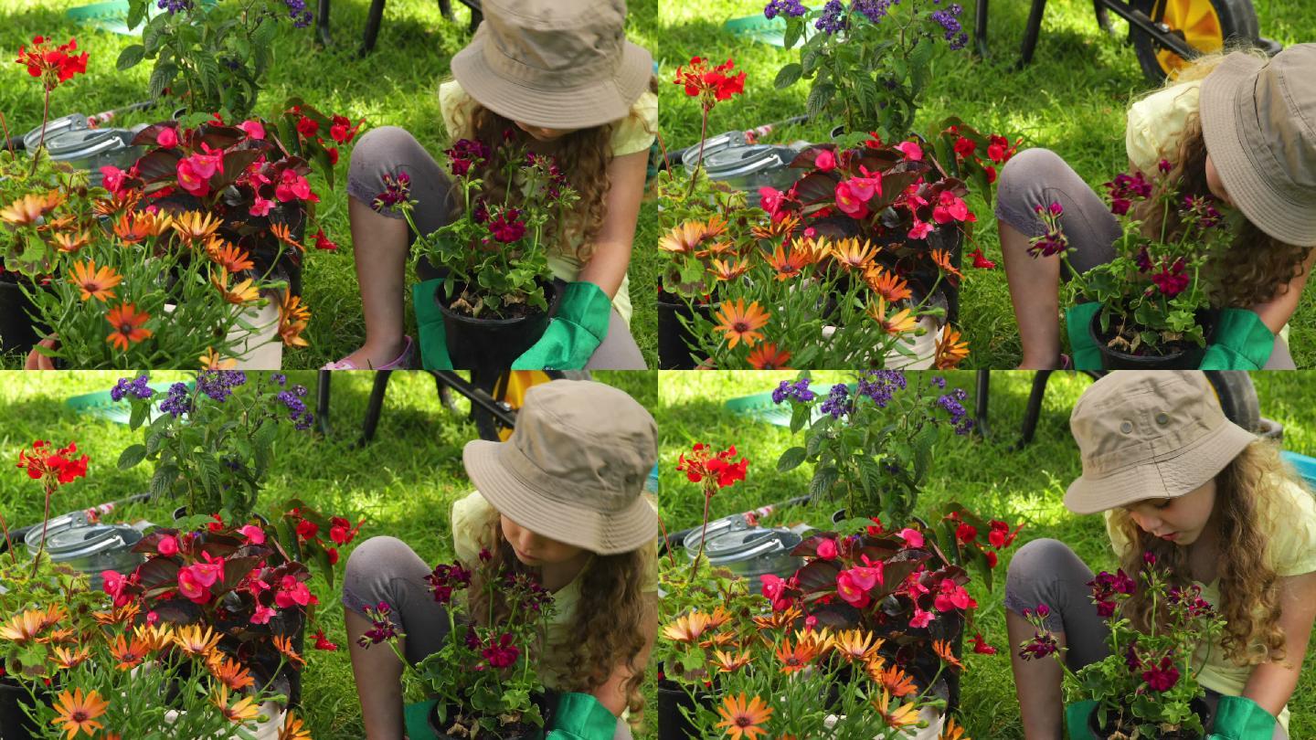 在一个阳光明媚的日子里，可爱的女孩在花园里捧着一盆花