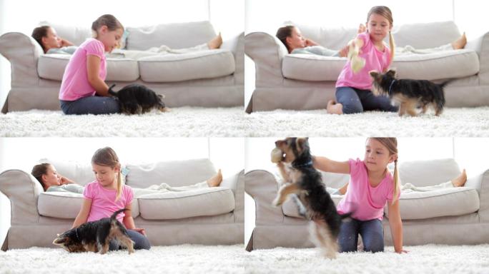 小女孩和她的妈妈在客厅的沙发上玩小狗和骨头