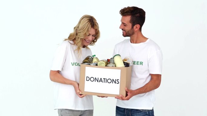 两名志愿者拿着一个捐款箱，背景是白色