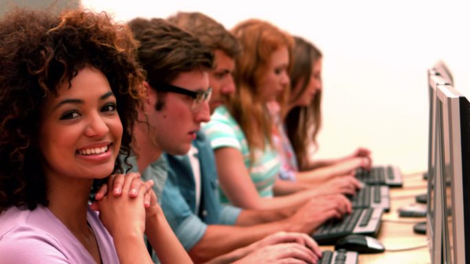 在电脑课上，快乐的学生对着镜头微笑的慢镜头