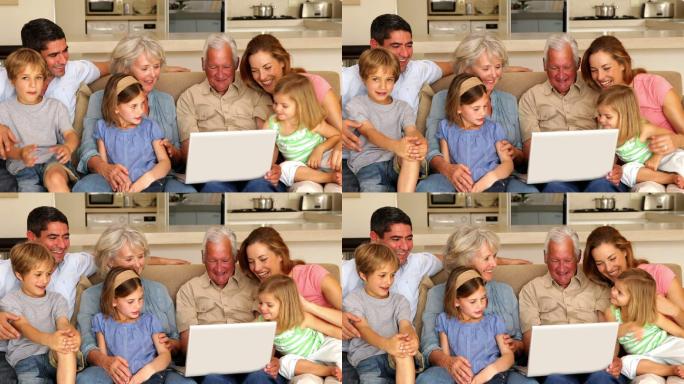 一大家族在客厅的沙发上一起使用笔记本电脑