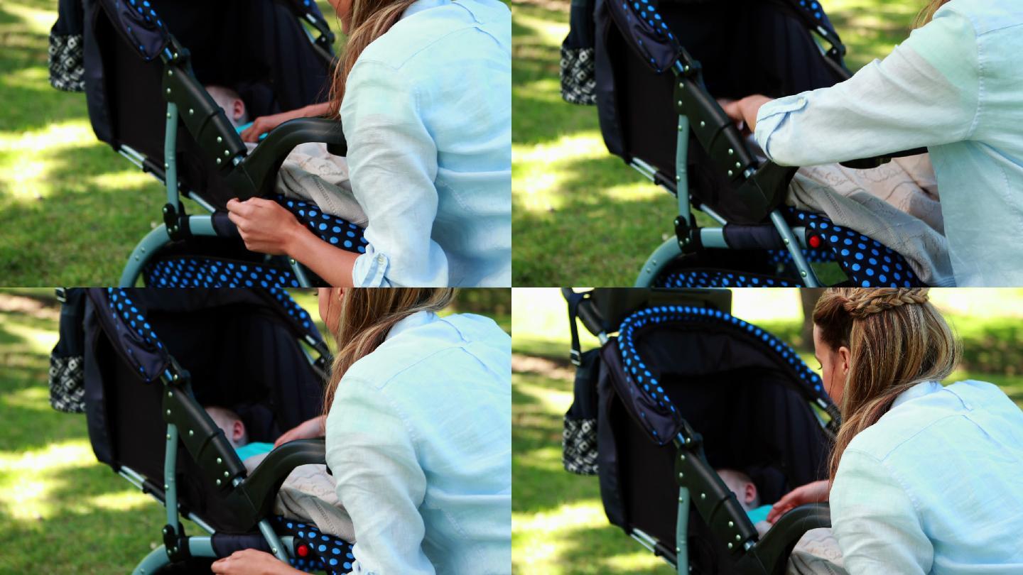 在一个阳光明媚的日子里，母亲在公园里检查婴儿车里熟睡的婴儿