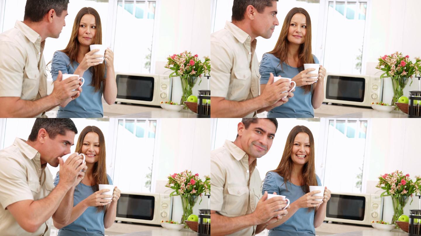 幸福的夫妇在厨房里一起喝咖啡