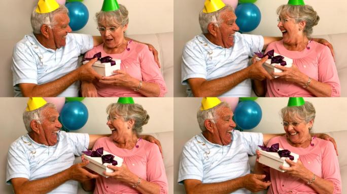 一对老年夫妇在沙发上慢镜头庆祝生日