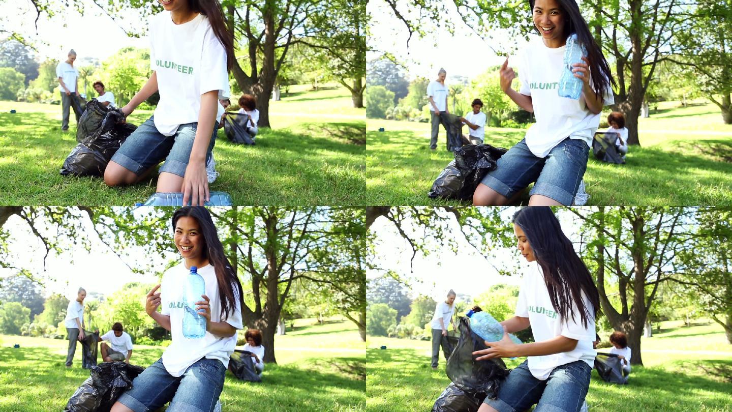 快乐的志愿者在一个阳光明媚的日子里在公园里捡垃圾
