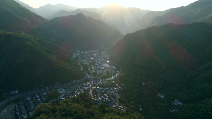 朝阳下群山环绕的山村