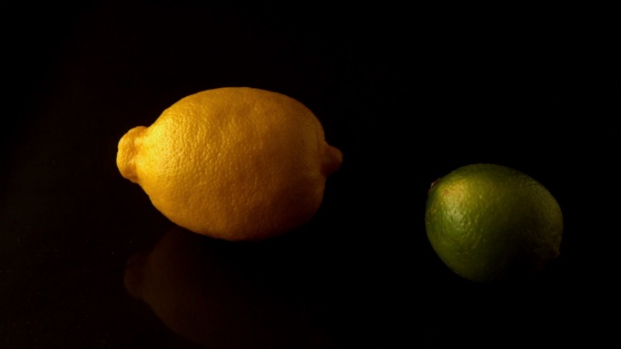 柠檬和酸橙在黑色背景旋转