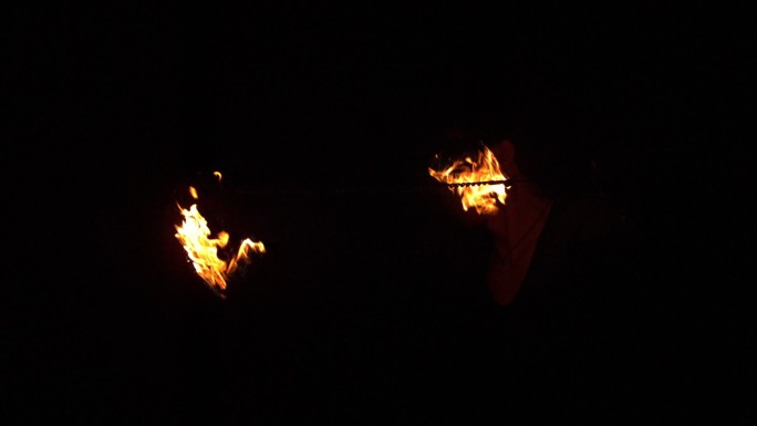 火焰舞者在黑暗中用慢动作旋转火焰