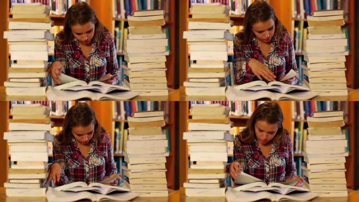 在大学里，专心学习的学生在图书馆周围的书