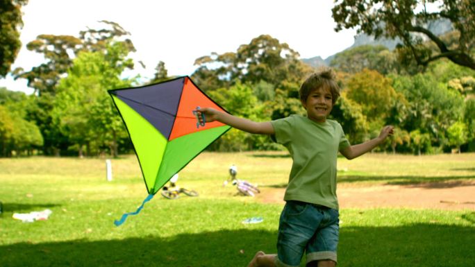 慢镜头里，小男孩在公园里玩风筝
