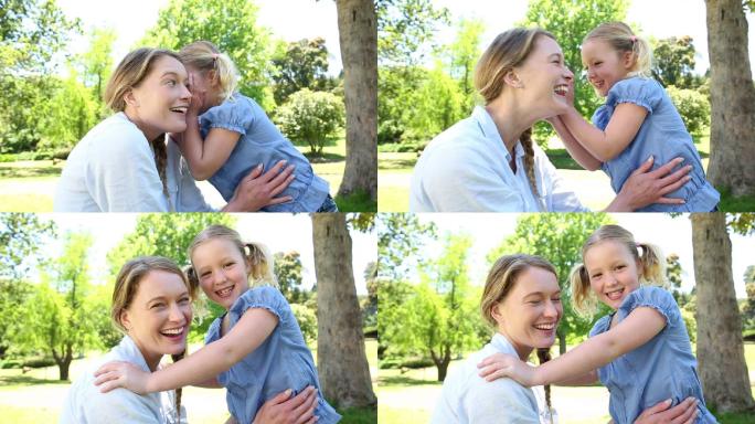 一个阳光明媚的日子，快乐的小女孩在公园里告诉她妈妈一个秘密
