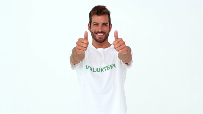 英俊的志愿者在白色背景下对着镜头竖起大拇指