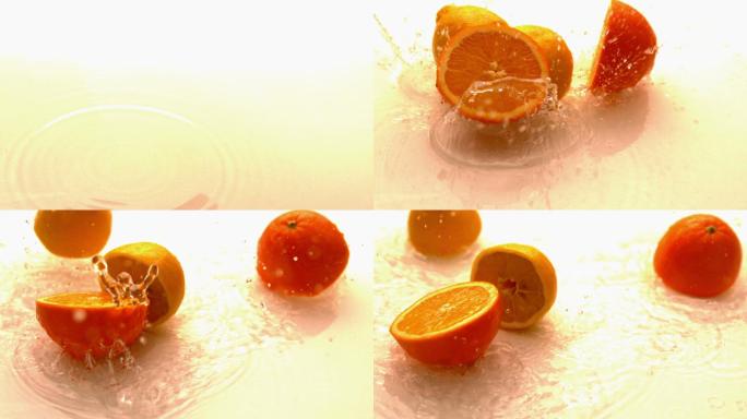 柠檬和橙子的一半在白色潮湿的表面缓慢下落和弹跳