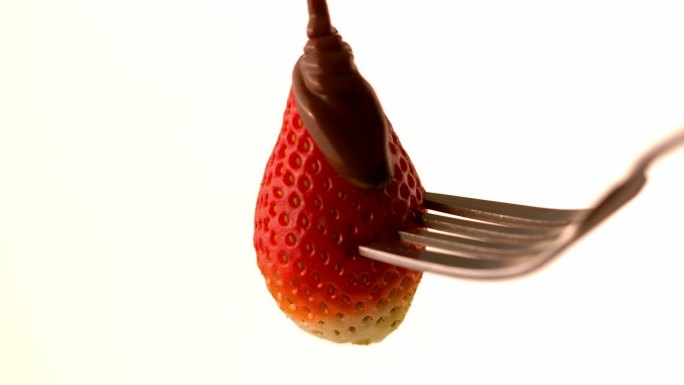 巧克力酱倒在草莓上的慢动作