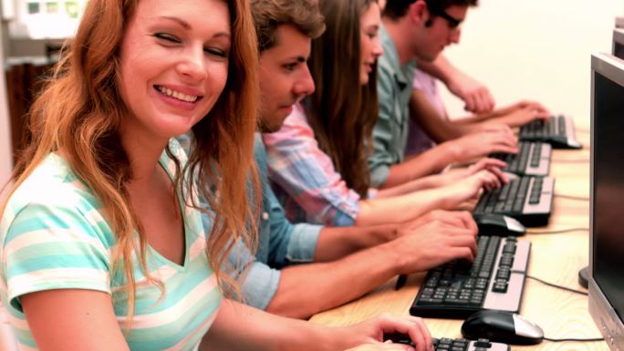 在电脑课上，快乐的学生对着镜头微笑的慢镜头