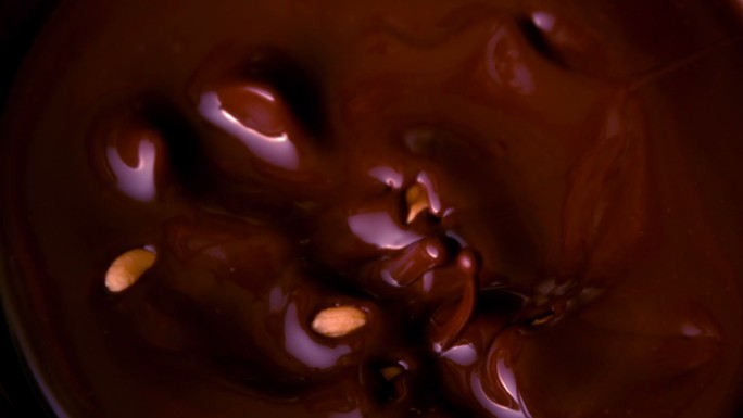 花生落在融化的巧克力里的慢镜头
