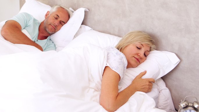 一对平静的夫妇睡在卧室的床上