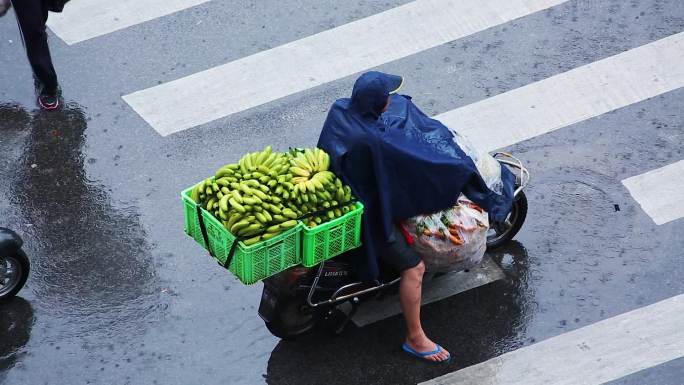 雨中骑电动车的市民和行人