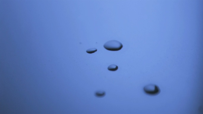在蓝光下，液滴以超慢的运动落在有液滴的表面上