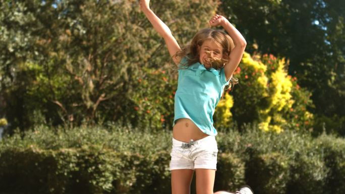 可爱的小女孩在她的花园里跳的慢镜头