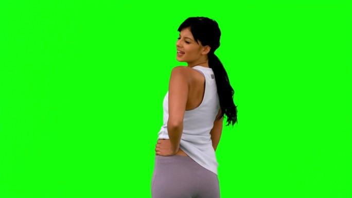 绿色屏幕下女人穿着运动服展示肌肉特写