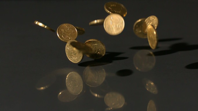 欧元硬币以慢镜头落到黑色表面