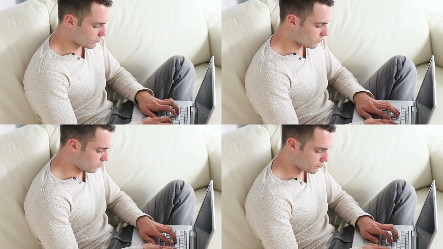 一个坐在沙发上用笔记本电脑打字的人