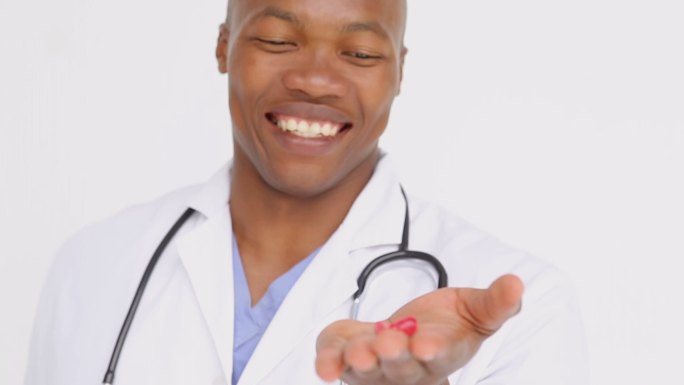 微笑的医生拿着维生素对白色的背景