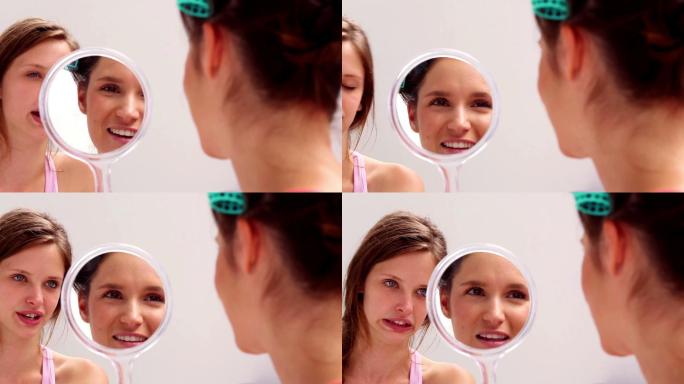 女孩戴着卷发棒照镜子，和朋友在家里聊天