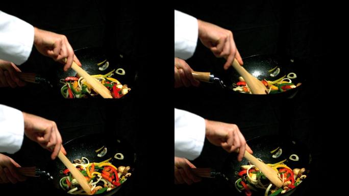 厨师在翻炒锅里的蔬菜特写