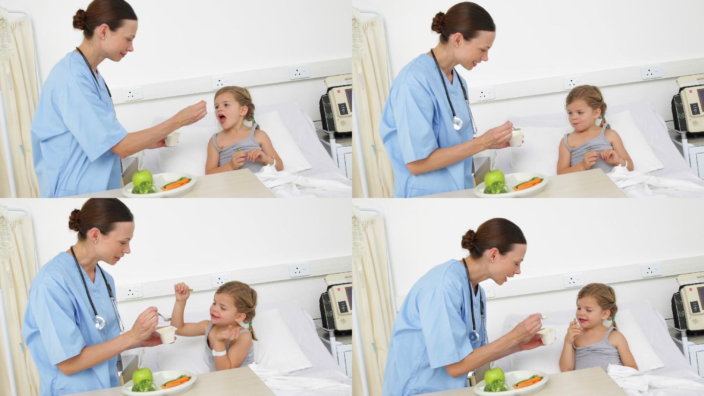 护士在医院给躺在病床上生病的小女孩喂奶