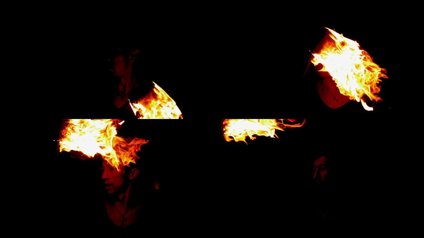 火焰舞者用慢动作在黑暗中让火焰从他的脸上掠过