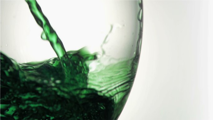 绿色液体被倒入玻璃杯中特写