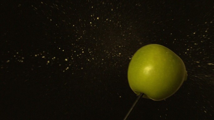 箭射过绿苹果在黑色背景的慢动作