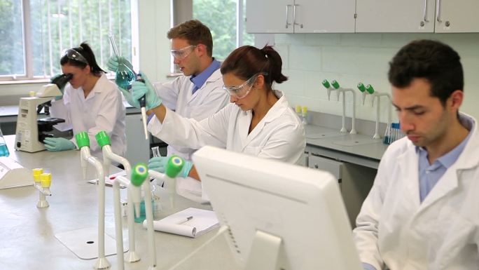一组专注于科学的年轻学生在大学的实验室一起工作