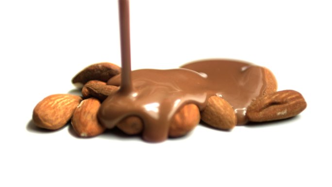 将融化的巧克力倒在杏仁上特写