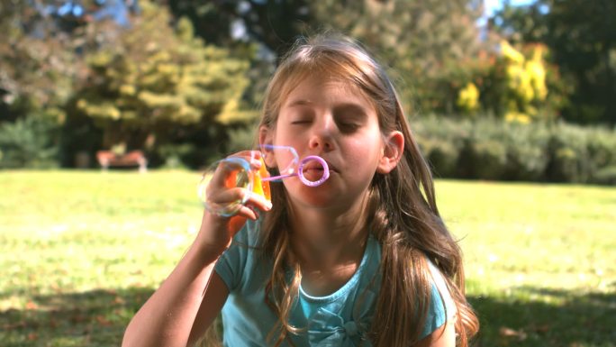 女孩在公园里玩吹泡泡特写