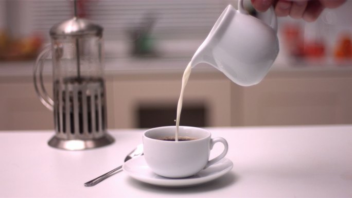 在厨房将牛奶倒入咖啡中特写