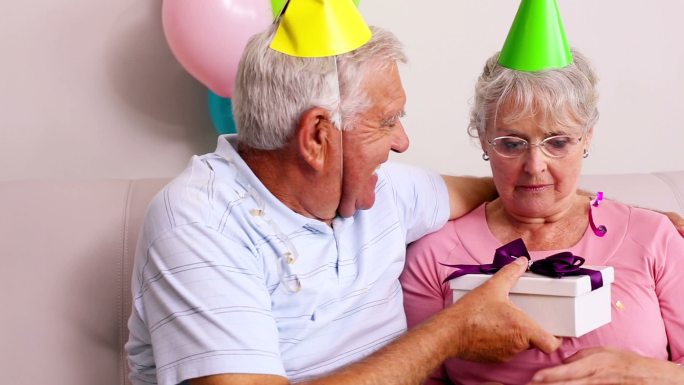 一对老年夫妇在客厅的沙发上庆祝生日