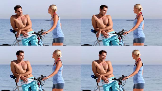 一对情侣推着自行车在海边聊天特写