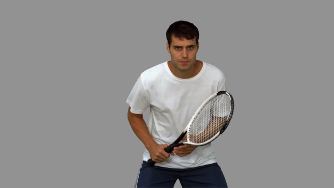 男人在灰色背景下练习打网球特写