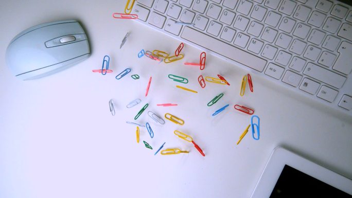 一堆回形针掉落在办公桌上特写