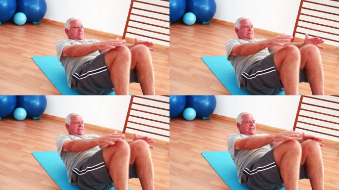 一个老年人在健身房做仰卧起坐