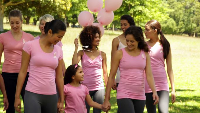 在一个阳光明媚的日子里，妇女们在公园里为乳腺癌宣传散步