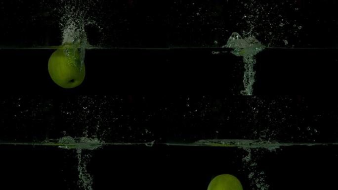 在黑色背景的慢镜头中，青苹果跳入水中
