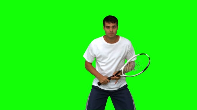 男人在绿色背景下练习打网球特写