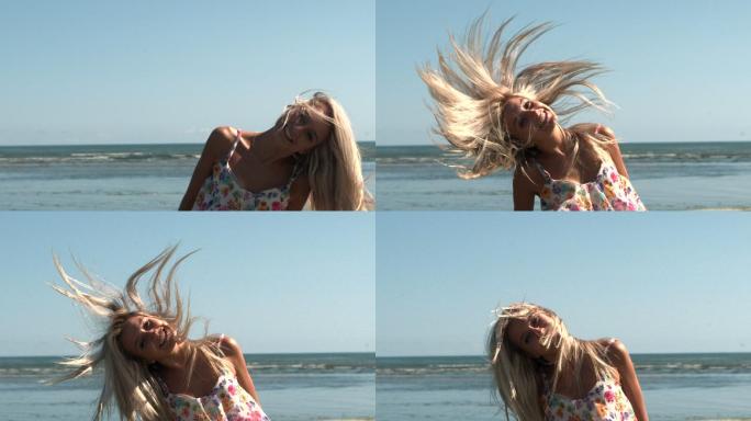 慢镜头里，快乐的金发女郎在沙滩上摇晃头发