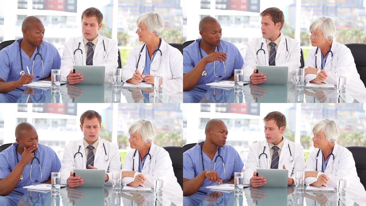 一个严肃的医生在明亮的房间里和他的同事谈论平板电脑